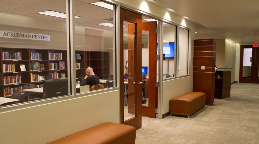 Interior of the Center, including a hallway with bench seating. The center library can be seen through glass windows.